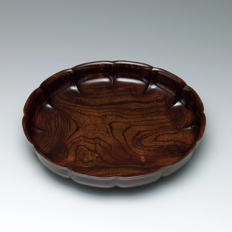 photo Flower-shaped food vessel of zelkova wood finished in wiped urushi.