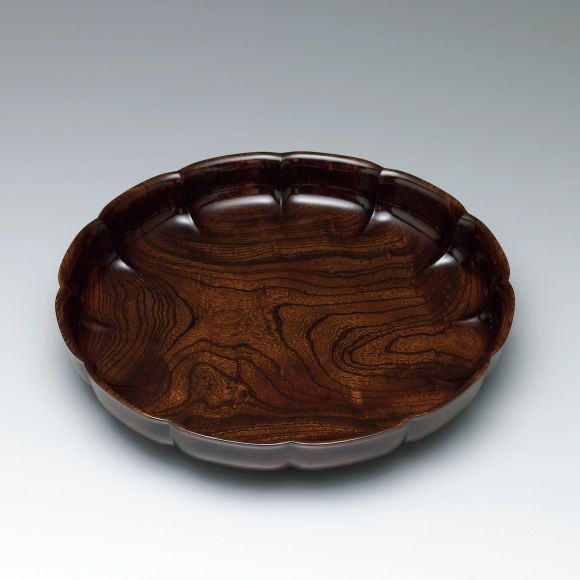 Flower-shaped food vessel of zelkova wood finished in wiped urushi.