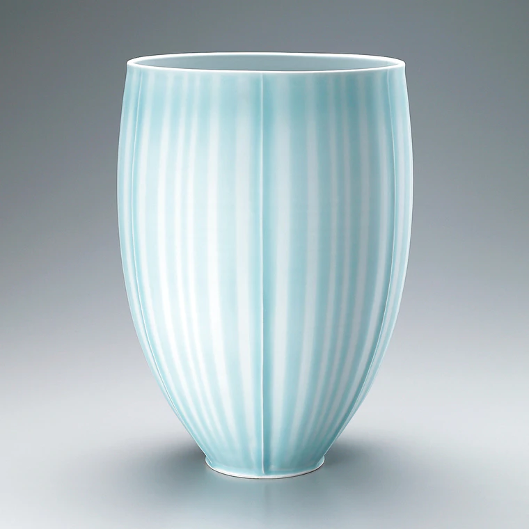 photo Flower vessel with celadon glaze and line design.