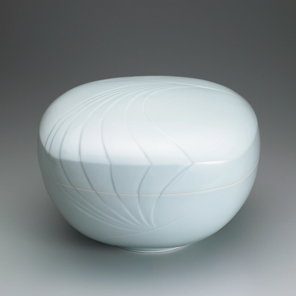 White porcelain covered bowl with pale blue glaze and engraved design.