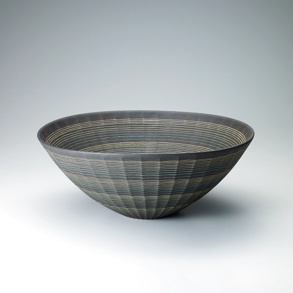Ridged bowl with inlaid line decoration and charcoal finish.