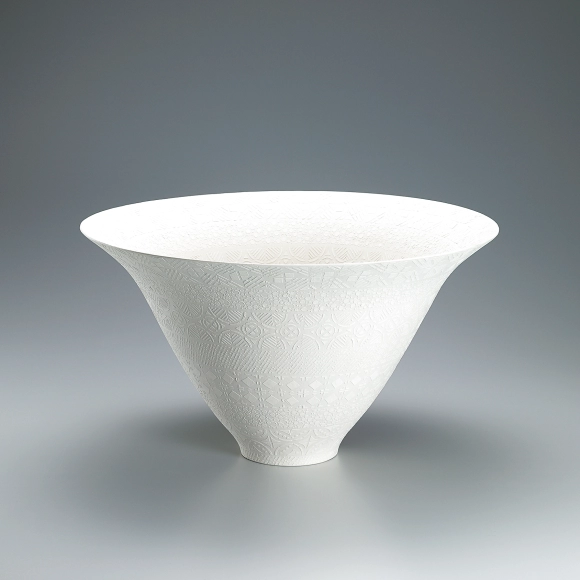 Bowl with design of tiered patterns in cut paper stencil.