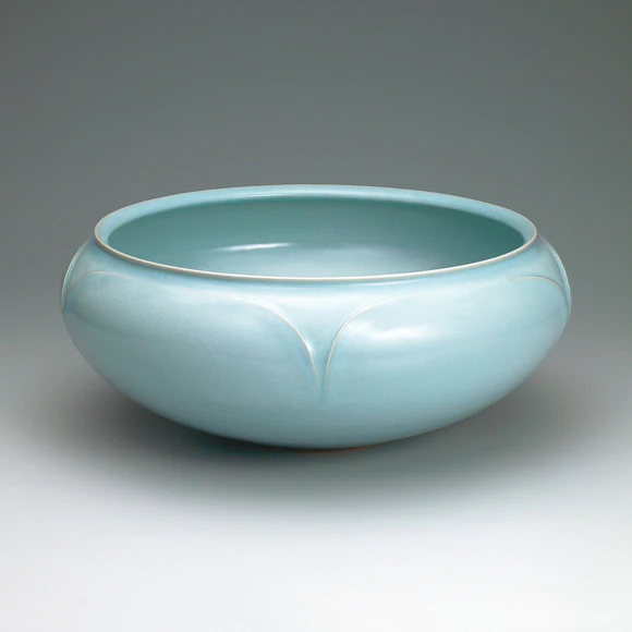 Bowl with celadon glaze and line design.