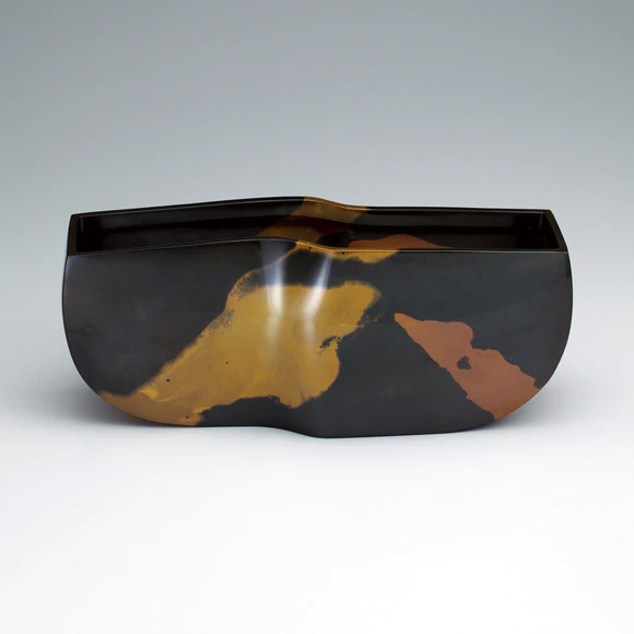 Flower vessel cast in two different metals.