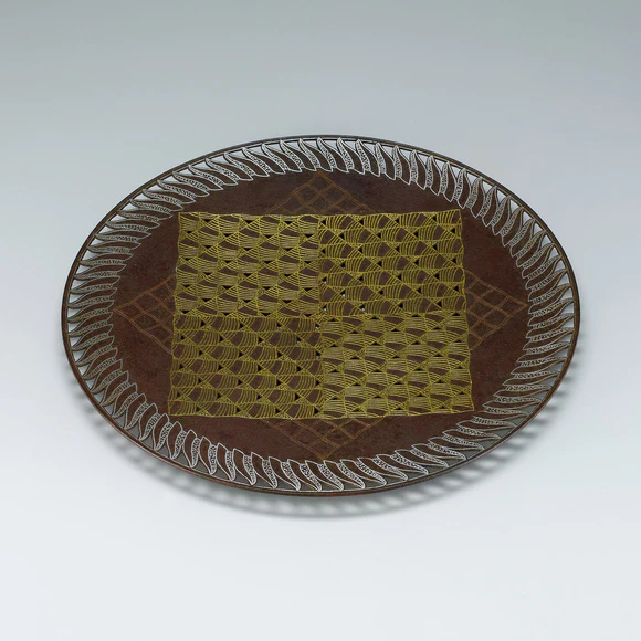 Iron plate with wave design in inlay.