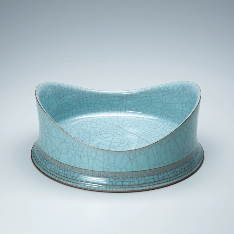 photo Bowl with two-wave crest shape rim, engraving around the base and cracked celadon glaze.