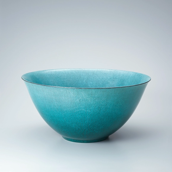 Green bowl with neatly aligned line design.