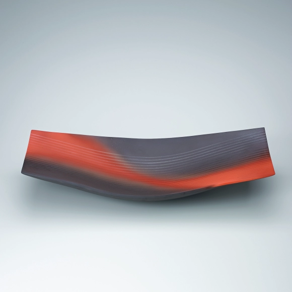 Red and black rectangular dish with line design.