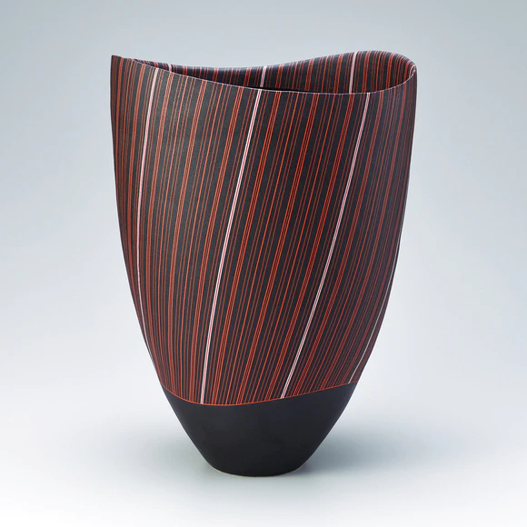 Vessel with stripe design on black background. 