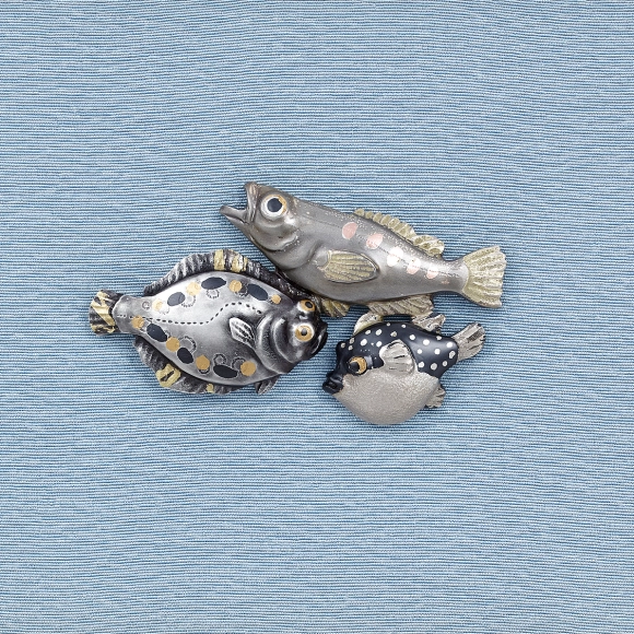 Metal fitting in shape of fishes.
