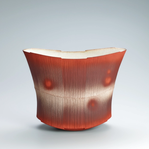 Red flower vessel with line design.