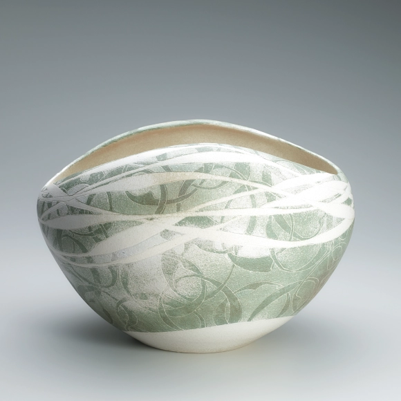 Flower vessel with lotus and circle design in colored slip.