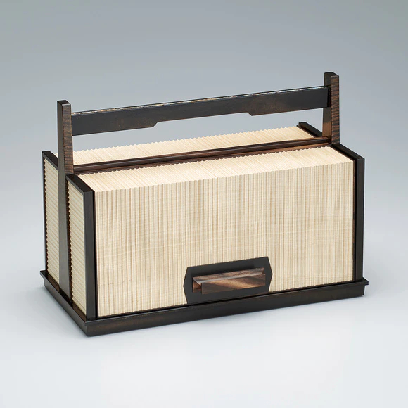 Small chest of drawers of horse chestnut wood and black persimmon wood with carrying handle.