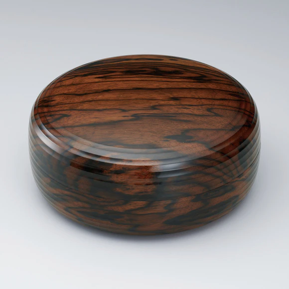 Covered food box of black-streaked persimmon wood with design in straight line.