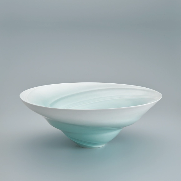 White porcelain bowl with pale blue glaze and sea current design.