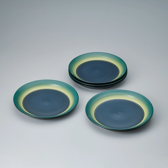 Set of flat dishes with colored glaze, engraved line and chattered pattern design.
