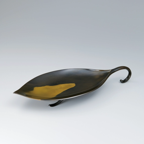 Leaf-shaped plate cast in two different metals.