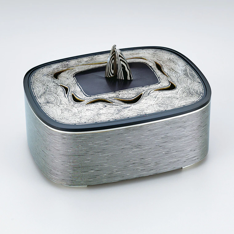 photo Layered metal incense burner with wave design.