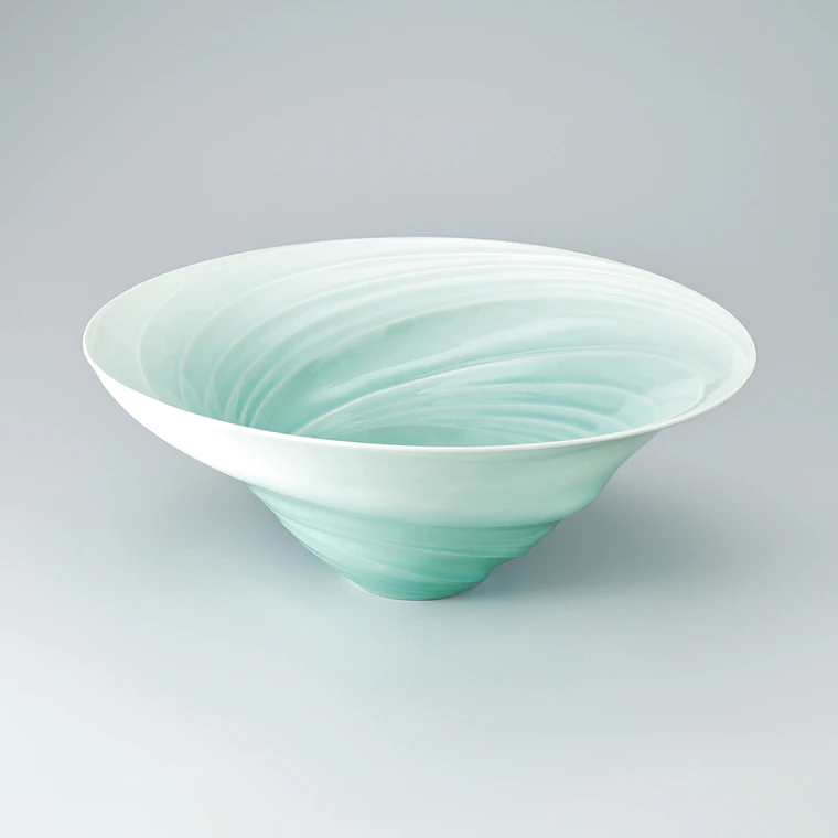 photo White porcelain bowl with pale blue glaze and tidal current design