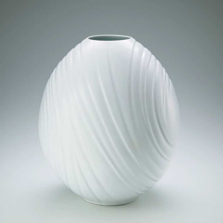 photo White porcelain flower vase with engraved decoration.