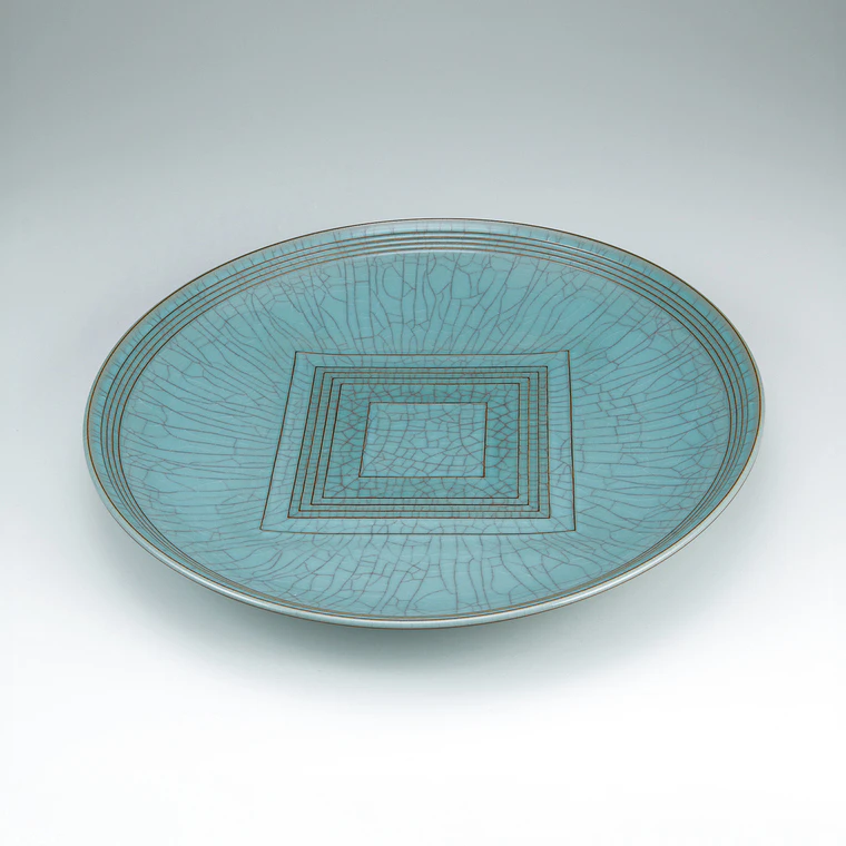 photo Large dish with celadon glaze and engraved circle and square design.
