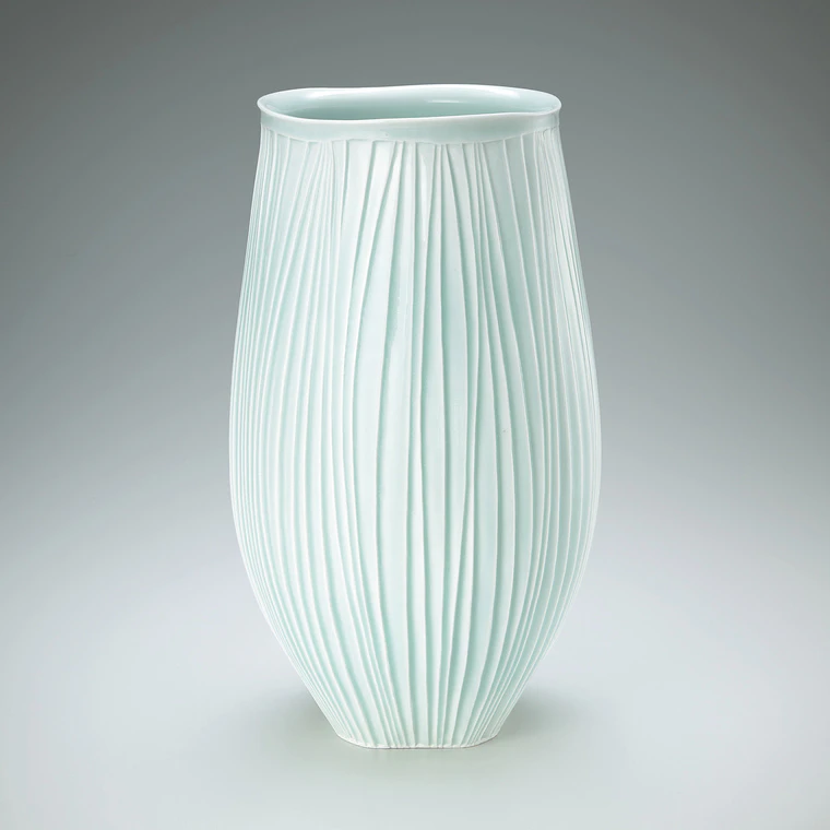 photo White porcelain deep bowl with pale blue glaze and ridged groove design.