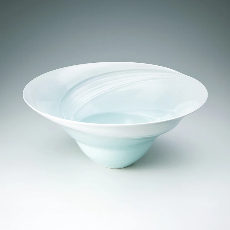 photo White porcelain bowl with pale blue glaze and tidal current design.