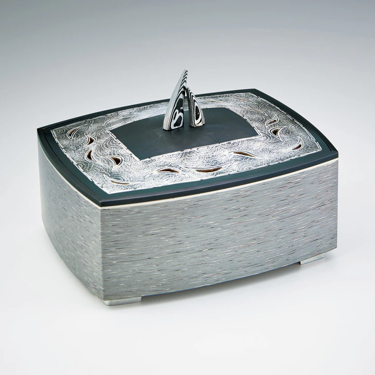photo Layered metal incense burner with wave design.