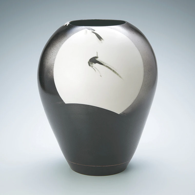 photo Jar with design of bird flying across the moon in black painting.
