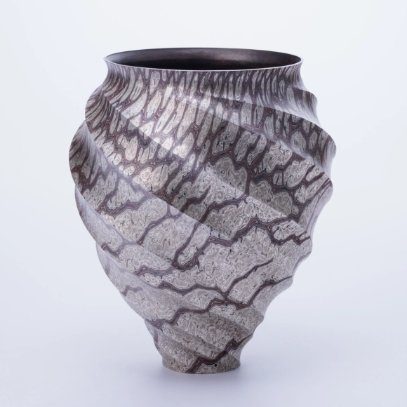 Twisted octagonal flower vessel of mokumegane made in hammer work.