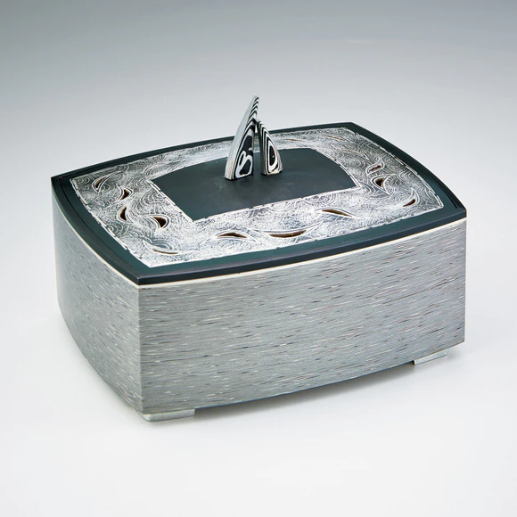 Layered metal incense burner with wave design.