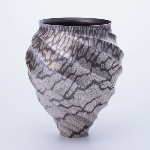 Twisted octagonal flower vessel of mokumegane made in hammer work.