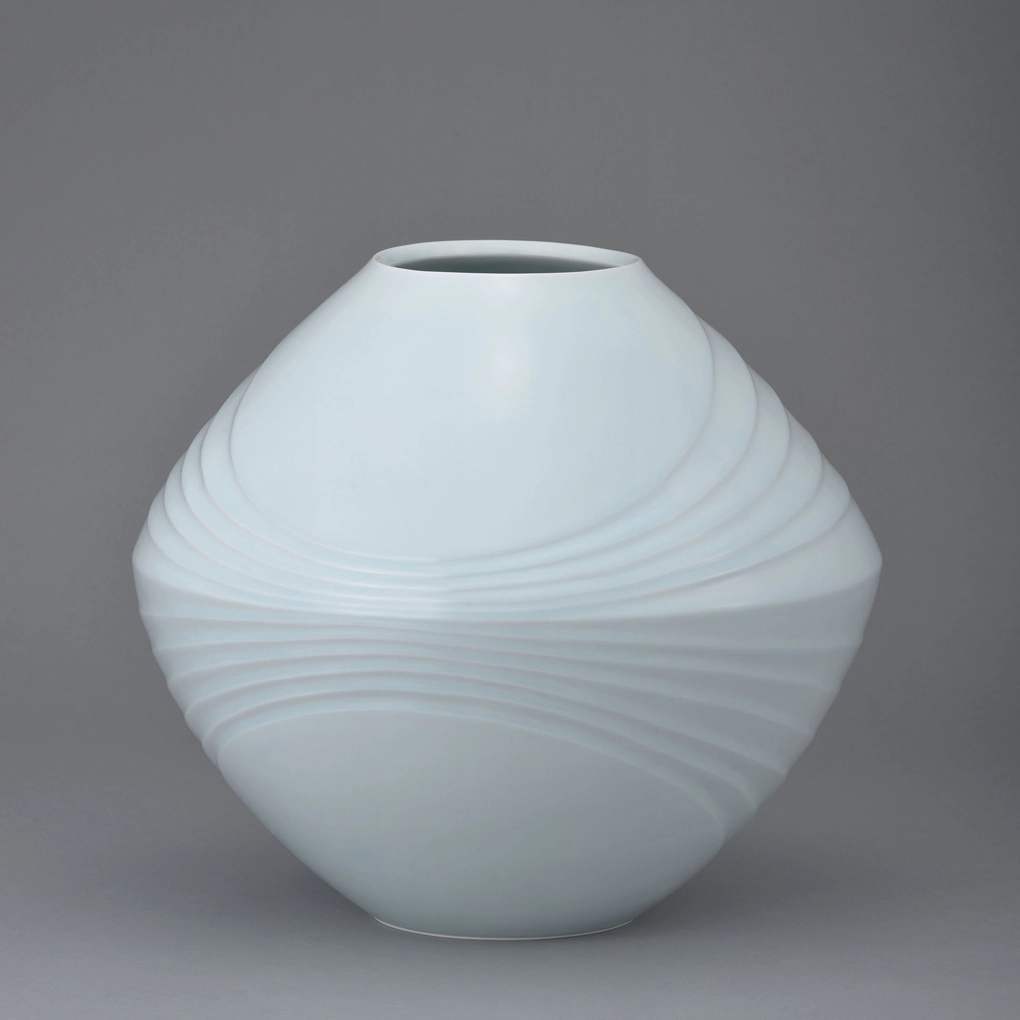 photo White Porcelain Vase with Pale Blue Glaze and Flowing Line Design